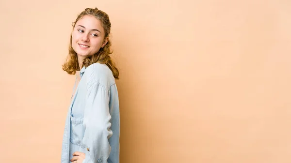 Jonge Kaukasische Vrouw Geïsoleerd Beige Achtergrond Vertrouwen Houden Handen Heupen — Stockfoto