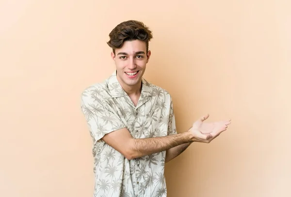 Young Caucasian Man Isolated Beige Background Holding Copy Space Palm — Stock Photo, Image