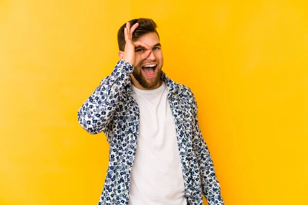 Kafkasyalı genç adam sarı arka planda izole edilmiş. Heyecanlı..