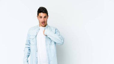 Beyaz arka planda izole edilmiş genç beyaz bir adam parmağını göstererek şaşırdı, geniş bir gülümsemeyle..