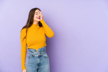 Mor arka planda soyutlanmış genç beyaz kadın gülüyor, kaygısız, doğal duygu..