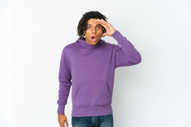 Genç Afro-Amerikan Rasta adam uzaklara bakıyor ve elini alnına koyuyor..
