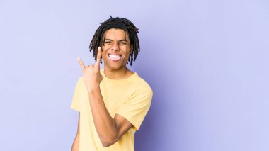 Genç Afrikalı Amerikalı Rasta adam parmaklarıyla rock hareketi yapıyor.