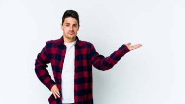 Beyaz arka planda izole edilmiş genç beyaz bir adam bir palmiye üzerinde fotokopi alanı gösteriyor ve belinde başka bir el tutuyor..