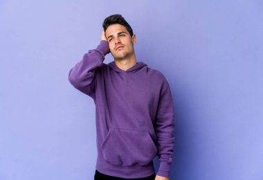 Mor arka planda izole edilmiş genç beyaz adam yorgun ve uykulu ellerini başının üstünde tutuyor..