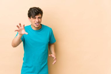 Genç havalı adam pençelerini kedi taklidi yapıyor, agresif bir hareket..