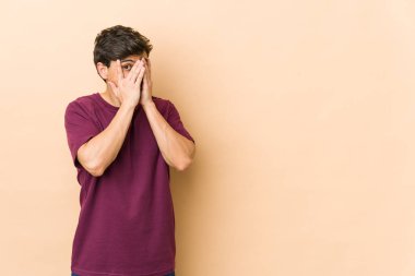 Genç havalı adam parmaklarıyla gözünü kırpıyor korkmuş ve gergin..