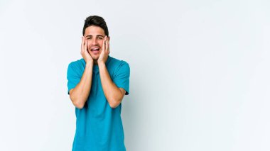 Beyaz arka planda ağlayan ve sızlanan beyaz tenli genç bir adam var..