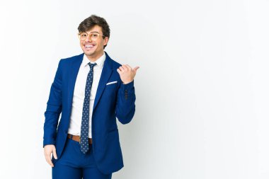 Genç iş adamı başparmağıyla işaret ediyor, gülüyor ve kaygısız..