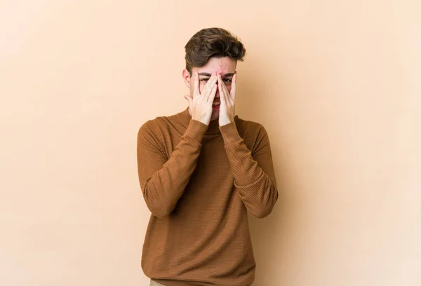 Young Caucasian Man Isolated Beige Background Blink Camera Fingers Embarrassed — Stock Photo, Image