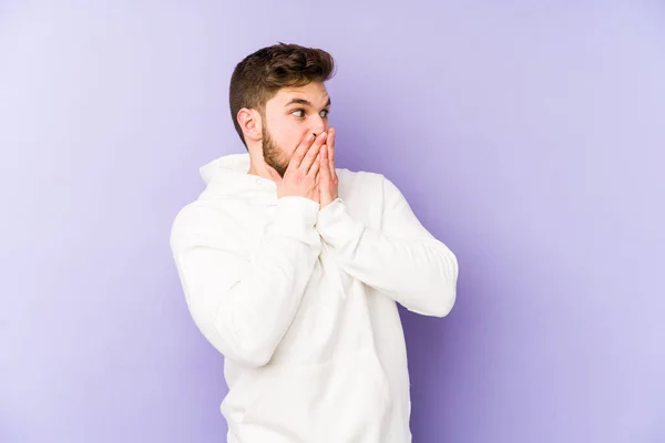 Giovane Uomo Caucasico Isolato Sfondo Viola Ridere Qualcosa Coprendo Bocca — Foto Stock