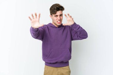 Beyaz arka planda izole edilmiş genç beyaz adam gergin elleriyle çığlık atıyor..