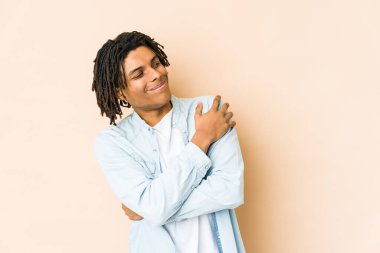 Genç Afro-Amerikan Rasta adamı sarılıyor, kaygısız ve mutlu gülümsüyor..