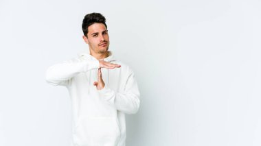 Beyaz arka planda izole edilmiş genç beyaz bir adam bir mola hareketi gösteriyor..