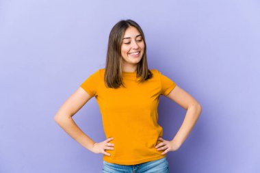 Genç beyaz kadın kendine güveniyor, ellerini kalçasında tutuyor..