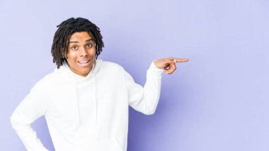 Genç Afrikalı Amerikalı Rasta adam işaret parmağıyla işaret ederek gülümsüyor..