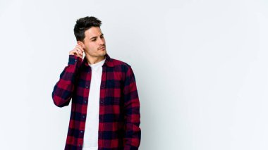 Beyaz arka planda izole edilmiş genç beyaz bir adam parmaklarıyla kulaklarını kapatıyor, gürültülü bir ortam yüzünden stresli ve çaresiz..