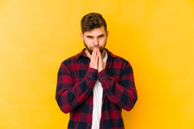 Kafkasyalı genç bir adam sarı arka planda izole edildi. Aklında bir plan oluşturdu..