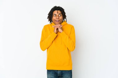 Afro-Amerikan Rasta 'lı genç adam şans için dua ediyor, şaşırmış ve ağzını açıyor..