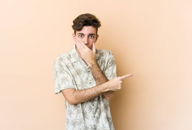 Beyazlı genç bir adam bej arka planda izole edilmiş.