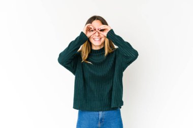 Beyaz arka planda izole edilmiş beyaz tenli genç bir kadın gözlerinde sorun olmadığını gösteriyor.