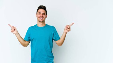 Beyaz arka planda izole edilmiş genç beyaz bir adam farklı kopya alanlarını gösteriyor, birini seçiyor, parmaklarıyla gösteriyor..