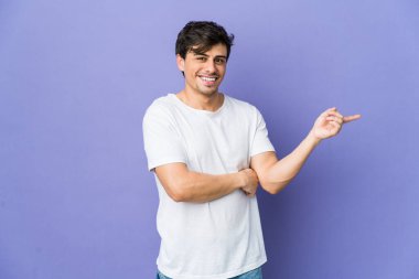 Genç, havalı adam işaret parmağıyla işaret ederek gülümsüyor..