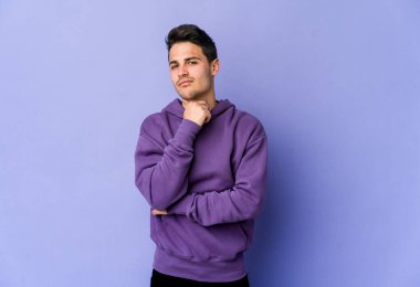 Mor arka planda izole edilmiş genç beyaz bir adam virüs veya enfeksiyon yüzünden boğazında ağrı hissediyor..