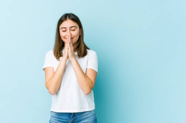 El ele tutuşup dua eden beyaz bir kadın, kendinden emin..