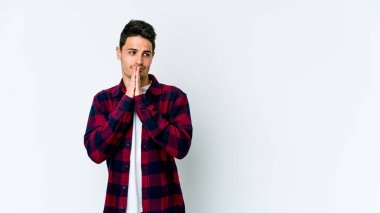 Beyaz arka planda izole edilmiş genç beyaz adam dua ediyor, bağlılık gösteriyor, dindar biri ilahi ilham arıyor..