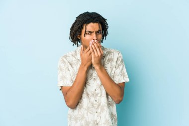 Genç Afro-Amerikan Rasta adam elleri ve ağzı kapalı endişeli görünüyor..