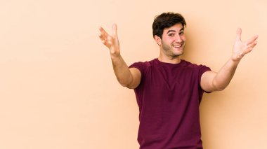 Bir zaferi ya da başarıyı kutlayan bej arka plandaki genç adam şaşırmış ve şok olmuştu..