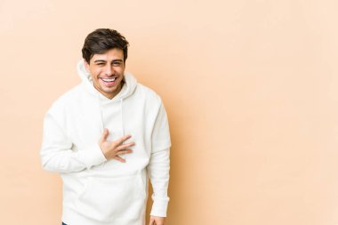 Genç havalı adam elini göğsünde tutarak kahkahalar atıyor..