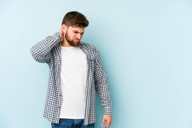 Kafkasyalı genç bir adam mavi arka planda izole edilmiş. Durağan yaşam tarzından dolayı boyun ağrısı çekiyor..