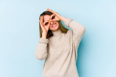 Mavi arka planda izole edilmiş beyaz bir kadın gözlerinde sorun olmadığını gösteriyor.