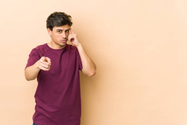 Genç, havalı bir adam şakağı parmağıyla işaret ediyor, düşünüyor, bir göreve odaklanıyor..