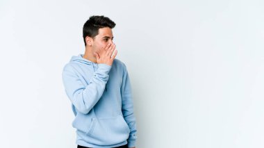 Beyaz arka planda izole edilmiş genç beyaz adam gördüğü bir şey yüzünden şoka uğruyor..