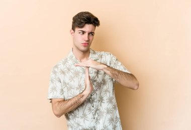 Beyazlı genç bir adam bej arka planda izole edilmiş..