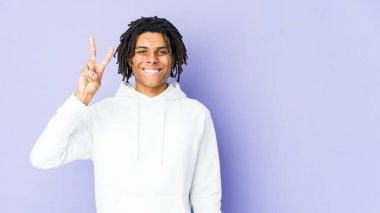 Genç Afrikalı Amerikalı Rasta adam neşeli ve kaygısız parmaklarıyla barış sembolü gösteriyor..