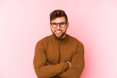 Genç beyaz adam pembe arka planda izole edilmiş gülüyor ve eğleniyor..