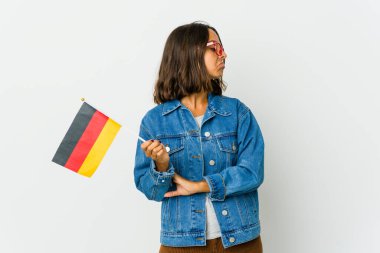 Beyaz arka planda izole edilmiş Alman bayrağı tutan genç Latin kadın tekrarlanan bir görevden yoruldu.
