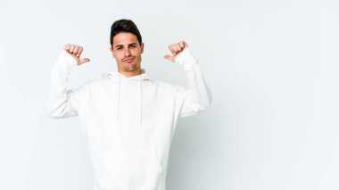 Beyaz arka planda izole edilmiş genç beyaz adam gururlu ve kendinden emin hissediyor, örnek olarak..