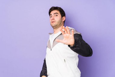 Mor arka planda izole genç bir adam yakın bir tehlike nedeniyle şoka uğruyor.