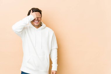 Genç, havalı adam elleriyle gözlerini kapatıyor, gülümseyerek bir sürpriz bekliyor..