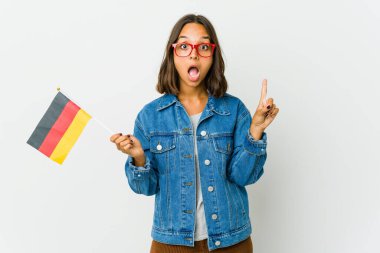 Beyaz arka planda izole edilmiş bir Alman bayrağı tutan genç Latin kadının bir fikri, ilham konsepti var..
