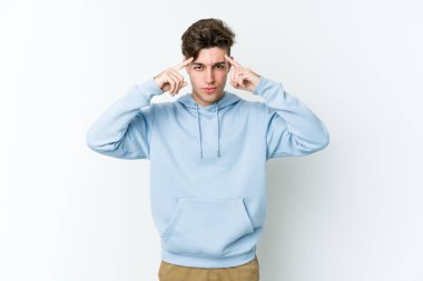 Beyaz arka planda izole edilmiş genç beyaz bir adam bir göreve odaklanmış, işaret parmaklarını işaret ediyor..