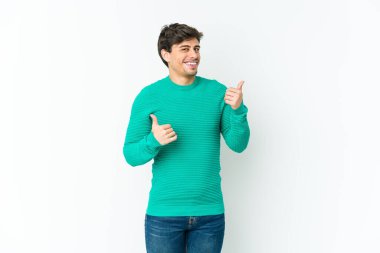Havalı genç adam iki parmağını da kaldırıyor, gülümsüyor ve kendinden emin..
