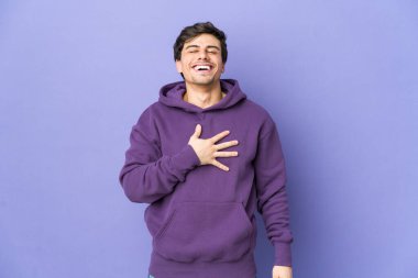 Genç havalı adam elini göğsünde tutarak kahkahalar atıyor..