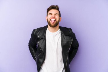 Mor arka planda izole edilmiş genç bir adam komik ve dost canlısı bir dil uzatıyor..