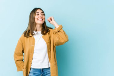 Genç beyaz kadın zafer, tutku ve coşkuyu kutluyor, mutlu bir ifade..